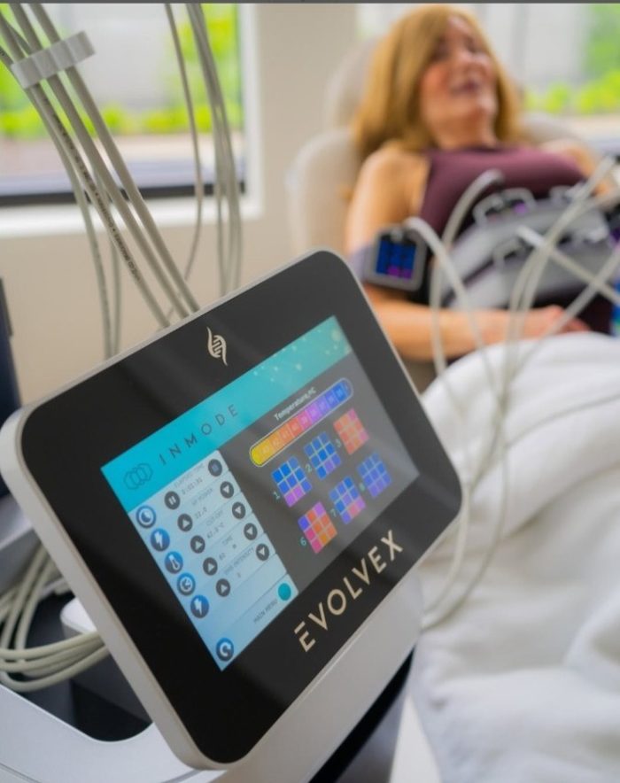 A client relaxing during an EvolveX treatment next to the treatment console